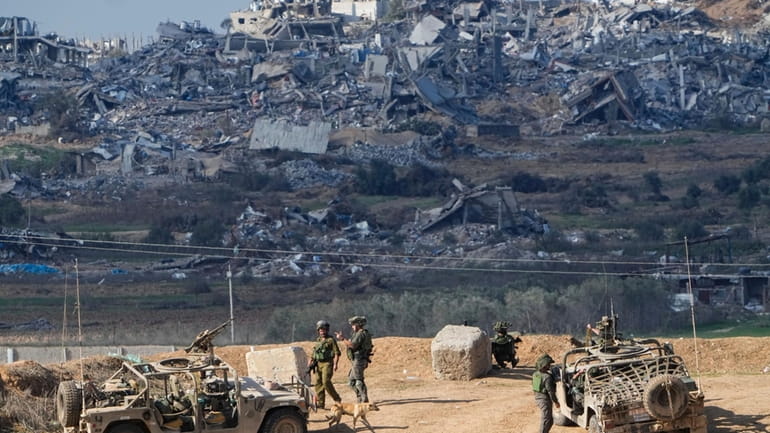 Israeli soldiers take up positions near the Gaza Strip border,...