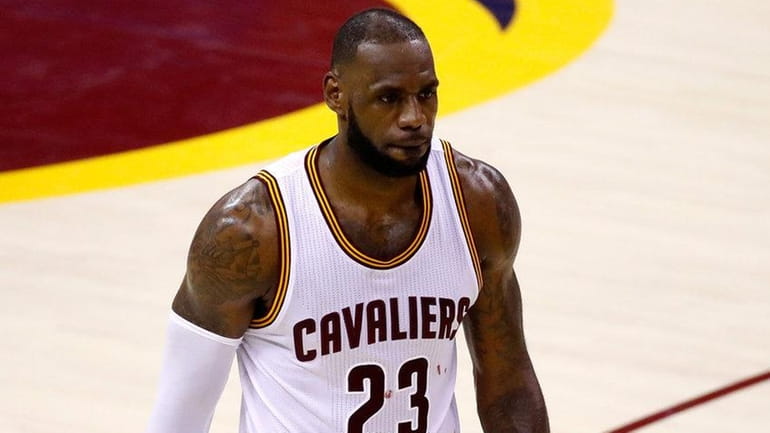 LeBron James of the Cavaliers walks off the court after...