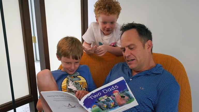 Wes Brown, right, reads to children Shawn Larimer-Brown, 7, left,...