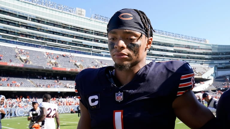 Chicago Bears quarterback Justin Fields walks off the field after...