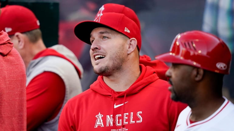 Los Angeles Angels center fielder Mike Trout speaks with teammates...