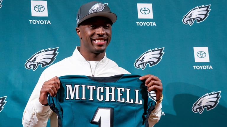 Philadelphia Eagles first-ound draft pick Quinyon Mitchell holds up a...