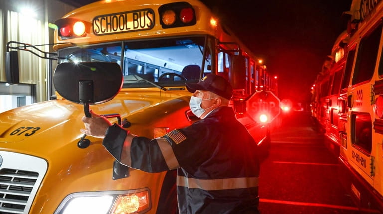 School bus driver Phil Greco adjusts his mirror at the...