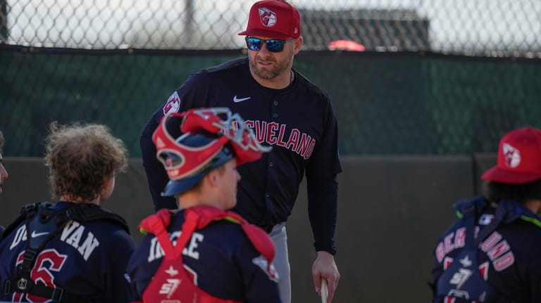 Cleveland Guardians manager Stephen Vogt, top,talks with catchers during spring...