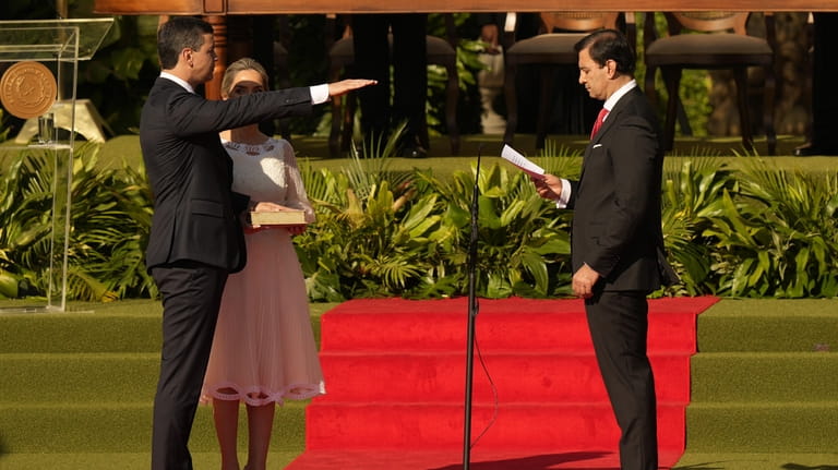 Paraguay's new President Santiago Pena, left, takes the oath of...