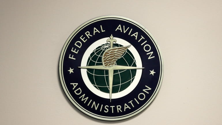 A Federal Aviation Administration sign hangs in the tower at...