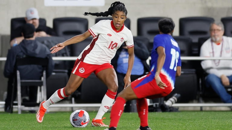 Canada's Ashley Lawrence, left, tries to dribble around United States'...