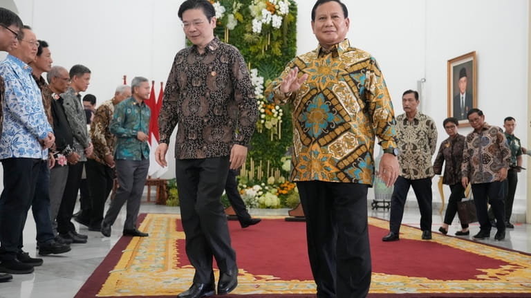 Indonesian Defense Minister and president-elect Prabowo Subianto, right, and Singapore's...