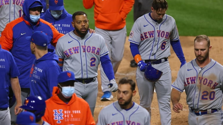 Dominic Smith #2 of the Mets walks off with his teammates...
