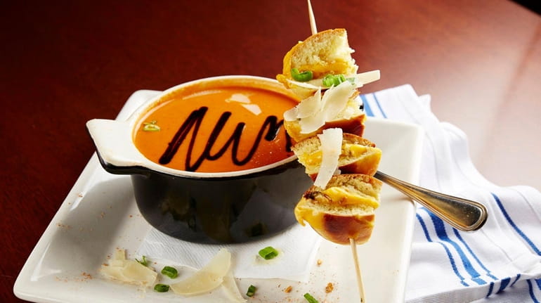Skewered mini grilled cheese sandwiches come with a bowl of...