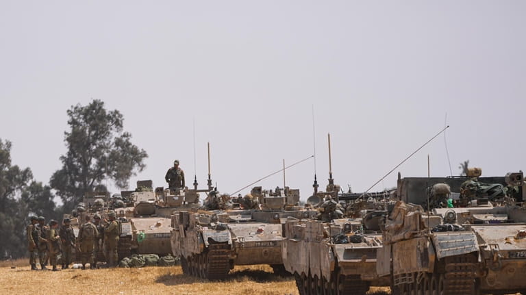 Israeli soldiers are seen at a staging ground near the...