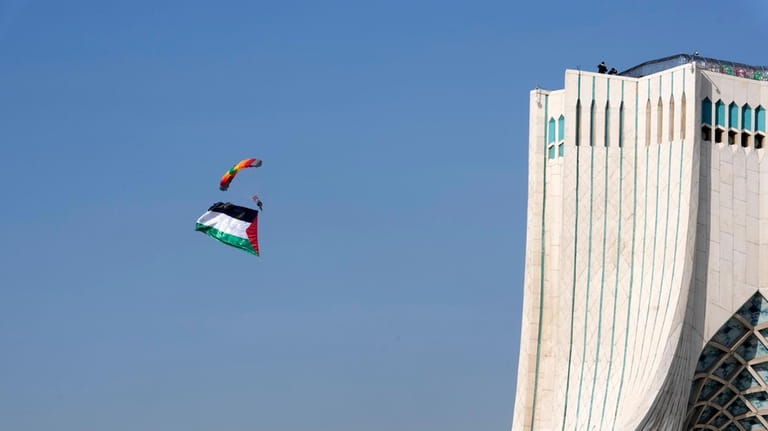 An Iranian paratrooper floats near the Azadi (Freedom) monument tower...
