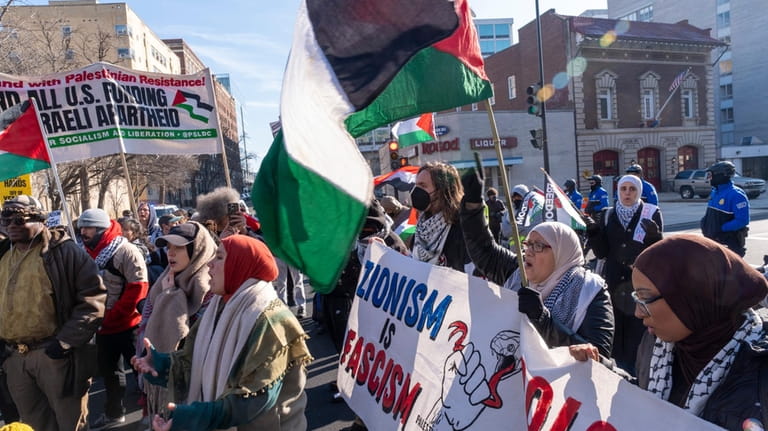 Pro-Palestinian protesters block the intersection of E St NW at...