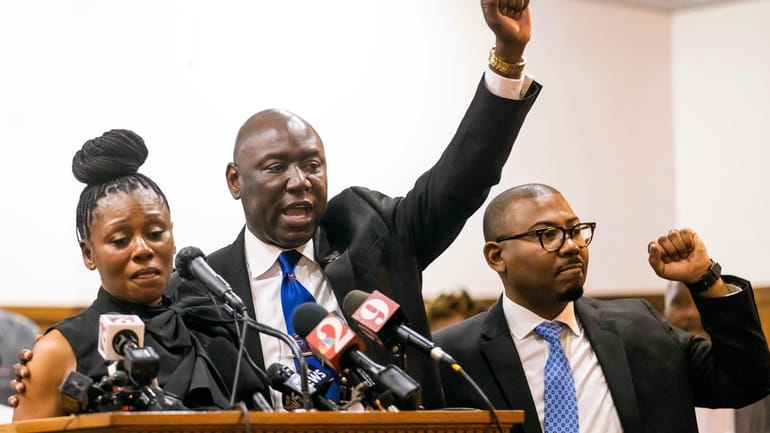 Attorney Ben Crump, center, shouts "Justice for A.J.!" while flanked...