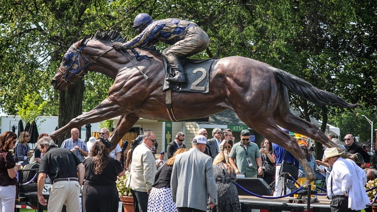 Racegoers check out the giant statue of Secretariat at Belmont...