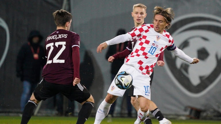 Croatia's Luka Modric, right, challenges for the ball with Latvia's...
