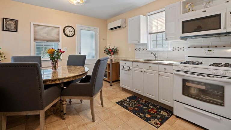 The kitchen has granite countertops and white cabinets.