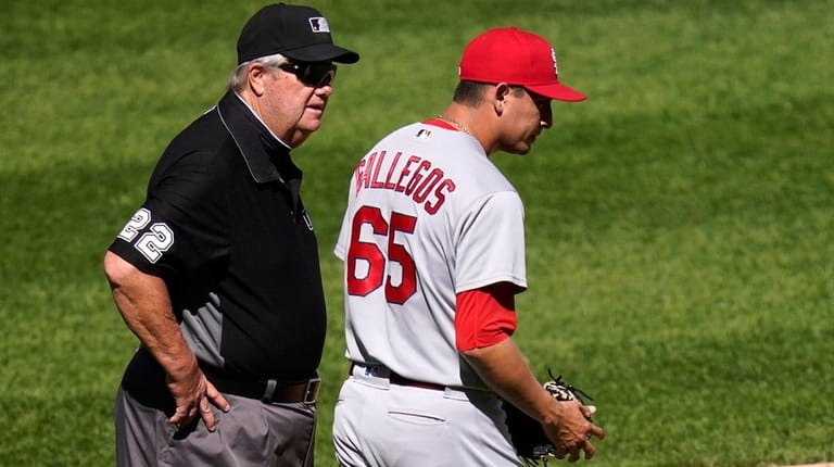 Cardinals reliever Gallegos gets wiped down by umpire after using