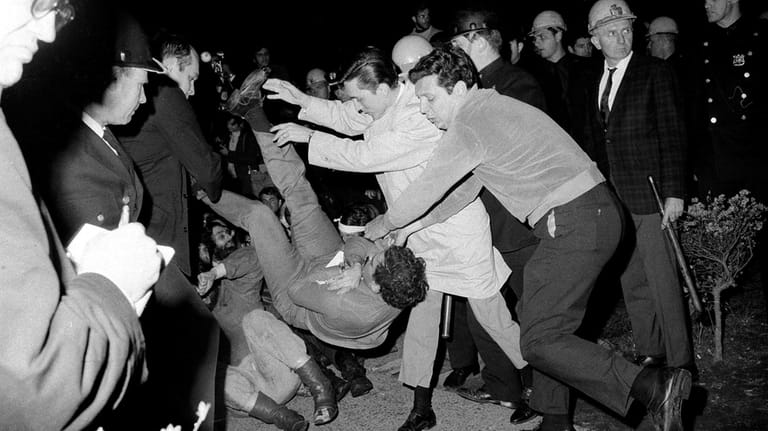 New York City plainclothes policemen drop a student protester on...