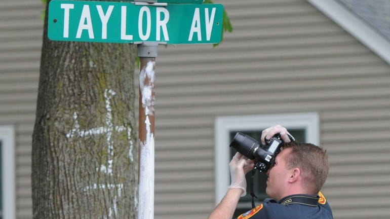 A Suffolk County police investigator photographs a swastika scrawled on...