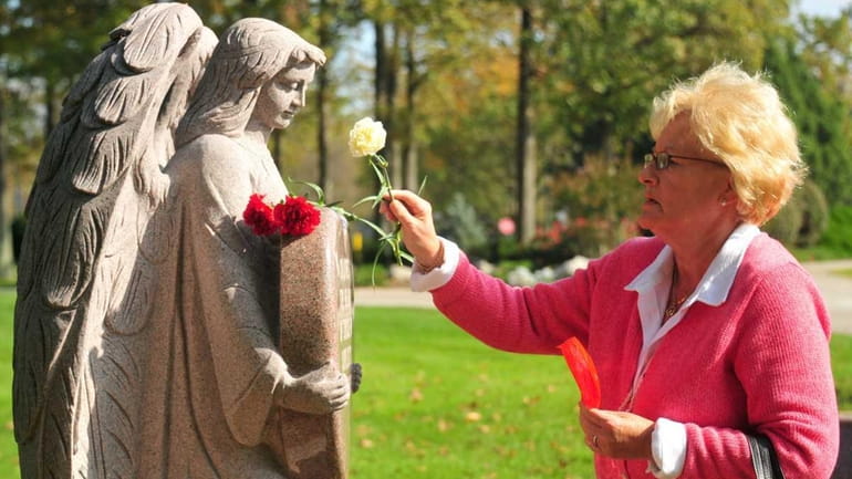 Anne Habeeb places a carnation in remembrance of her daughter...