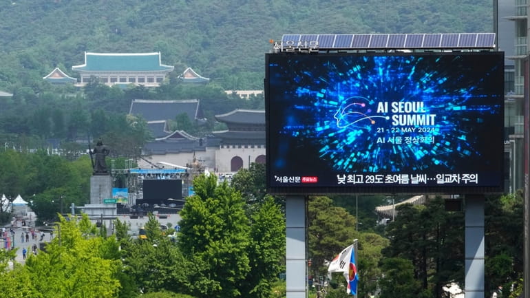 A screen shows an announcement of the AI Seoul Summit...