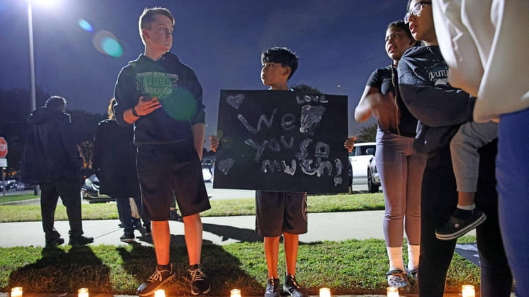 Damian Loredo 10, holds a sign of support along the...