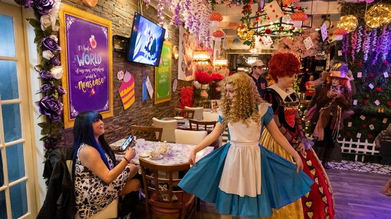 Characters from “Alice in Wonderland” perform and greet guests at The...