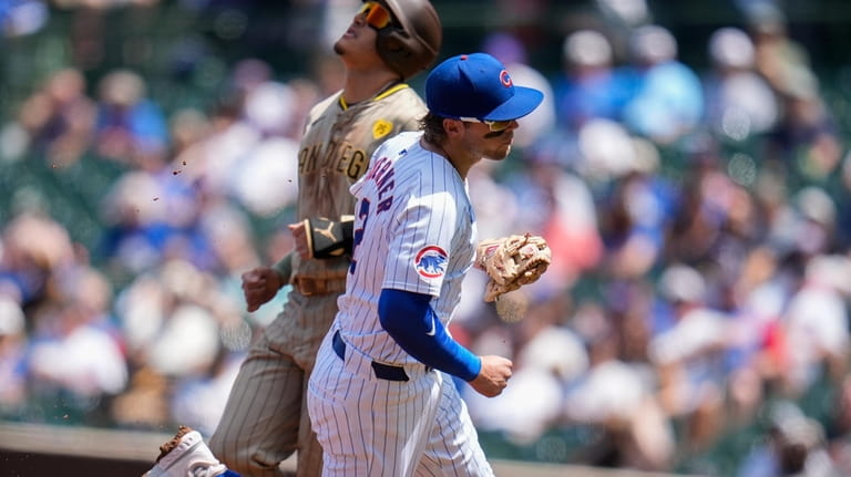Chicago Cubs shortstop Nico Hoerner, right, forces out San Diego...