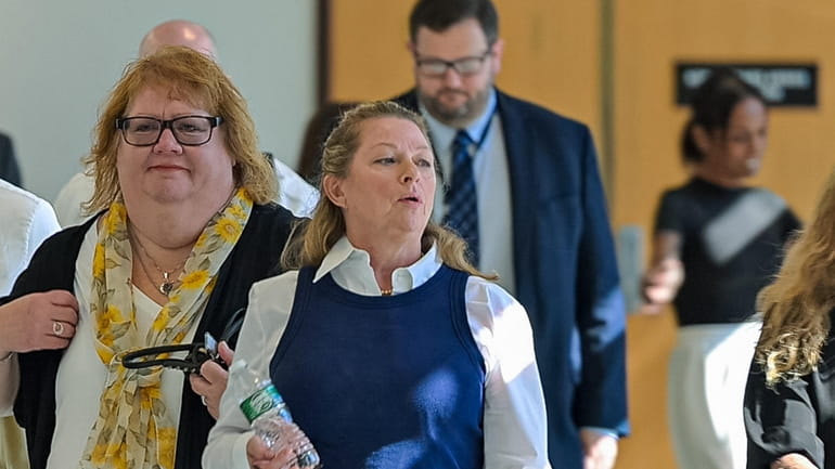 Ann Marie Drago, middle, leaves a Riverhead courtroom during recess at her...