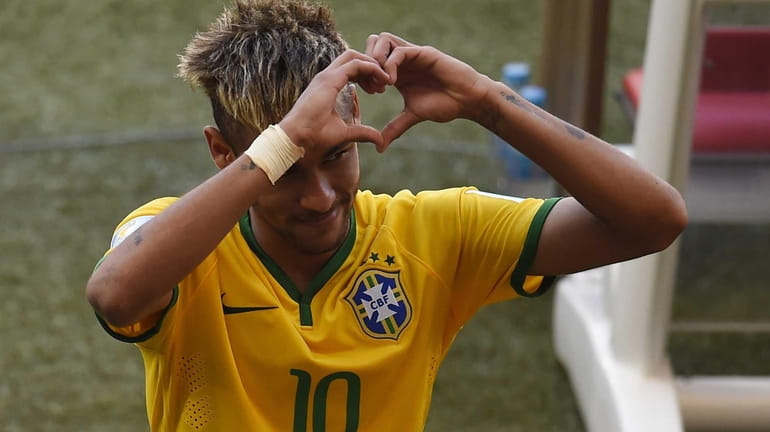 Brazil's forward Neymar gestures towards the fans as he celebrates...