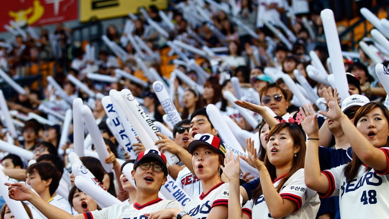 FILE- Fans of the South Korean baseball team Doosan Bears...