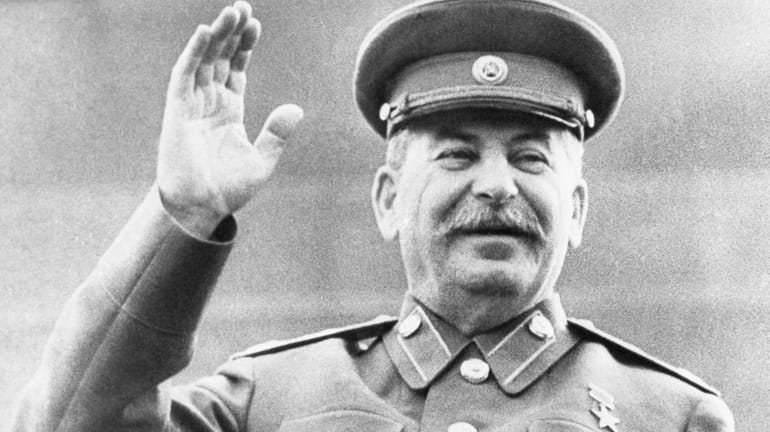 Soviet leader Josef Stalin raises his right hand in salute...