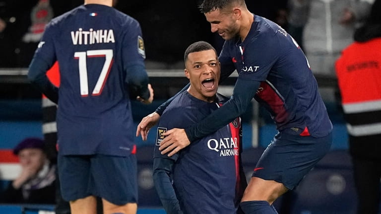 PSG's Kylian Mbappe, center, celebrates with teammates after scoring his...