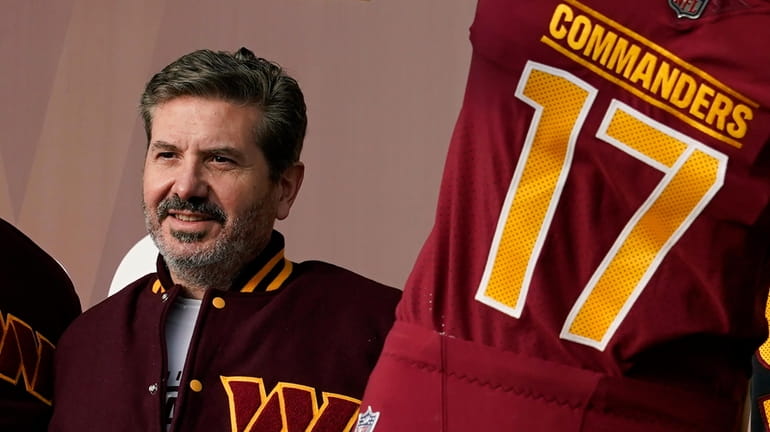 The Commanders' Dan Snyder poses for photos during an event...