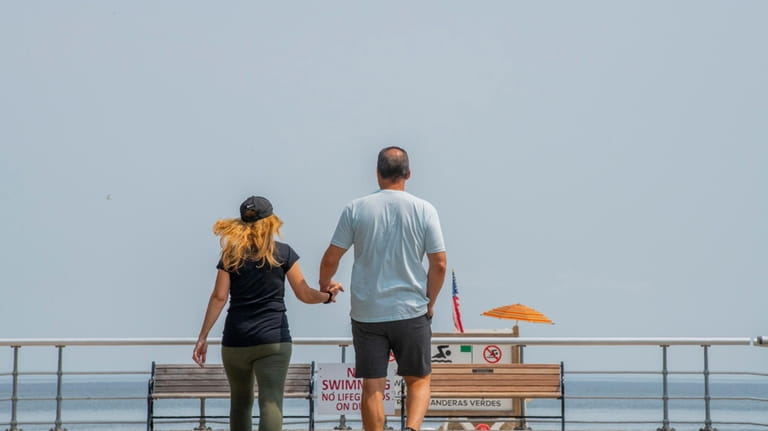 A couple walks the boardwalk hand in hand at Sunken...