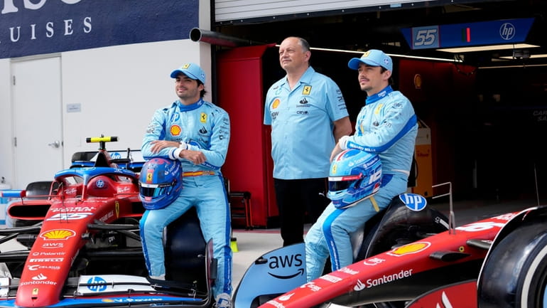Ferrari driver Carlos Sainz, of Spain, left, Ferrari team principal...