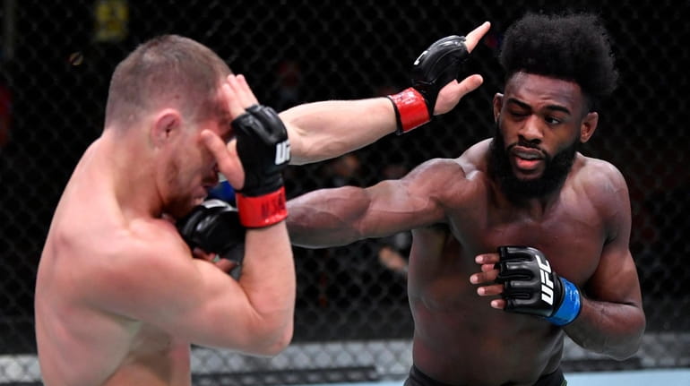Aljamain Sterling punches Petr Yan in their bantamweight championship fight during...