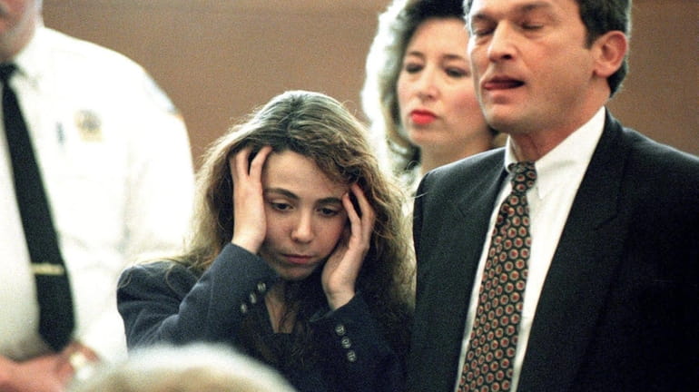 Amy Fisher, standing beside attorney Eric Naiburg, reacts to the...