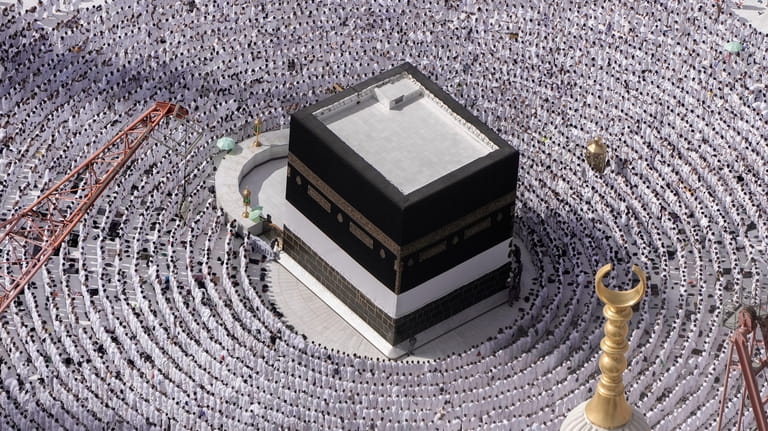 Muslim pilgrims pray around the Kaaba, the cubic building at...