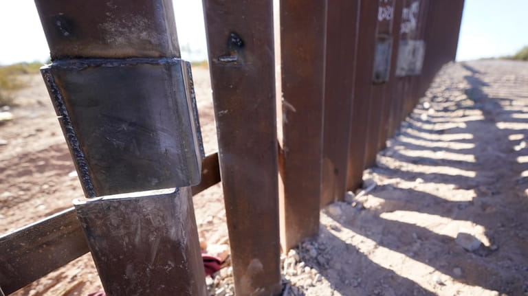 One of the steel columns of the border wall separating...