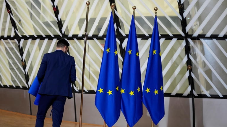 A member of protocol looks at EU flags prior to...
