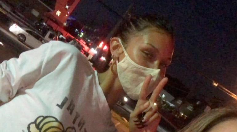 Supermodel Bella Hadid, wearing mask, poses for a photo with Jenna...