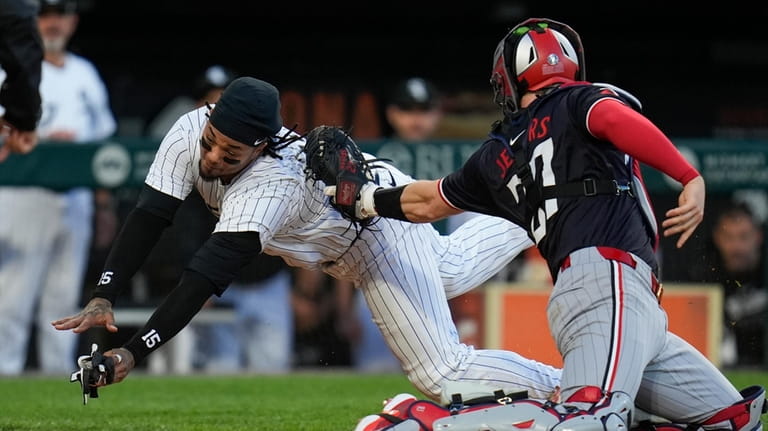 Chicago White Sox's Martín Maldonado is tagged out a home...