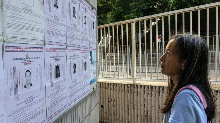 A pedestrian looks at the police reward notices for the...