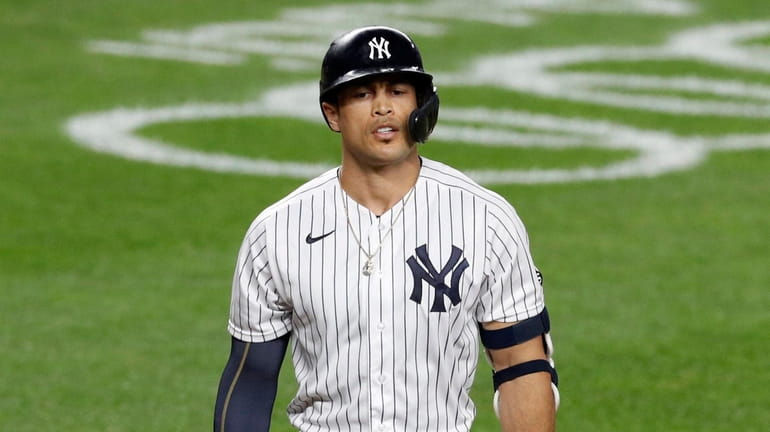 Giancarlo Stanton #27 of the Yankees walks back to the...