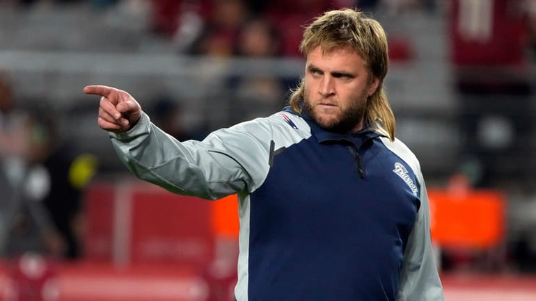 New England Patriots linebacker coach Steve Belichick warms up before...