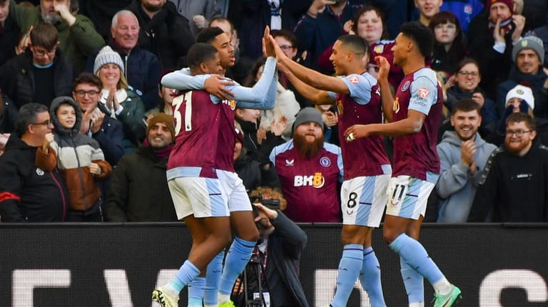 Aston Villa's Leon Bailey, left, celebrates after scoring his side's...