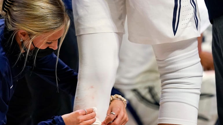 A trainer cleans blood off of the uniform of Xavier...