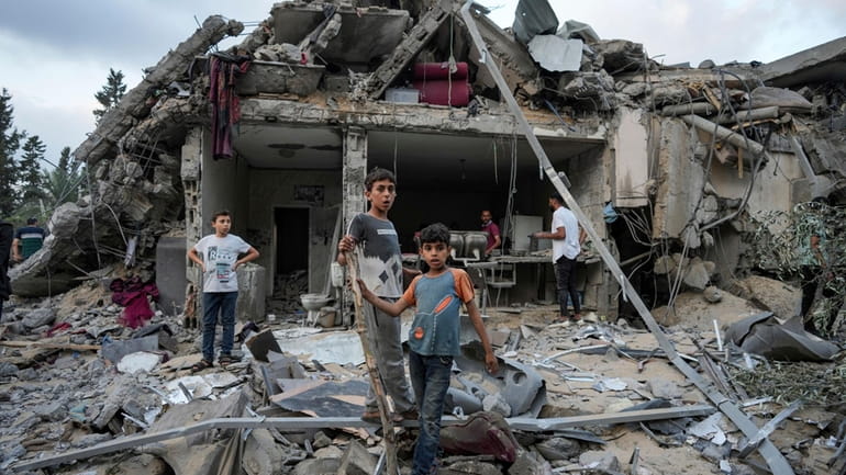 Palestinians look at the destruction after an Israeli airstrike in...